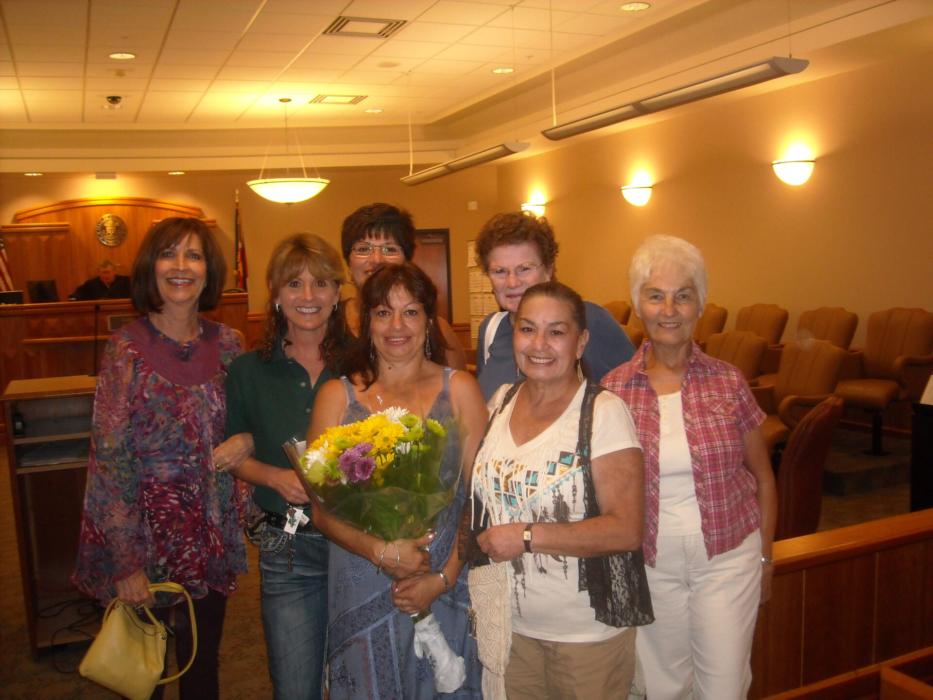 A group of people standing together holding flowers.