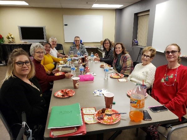 A group of people sitting at a table with plates.