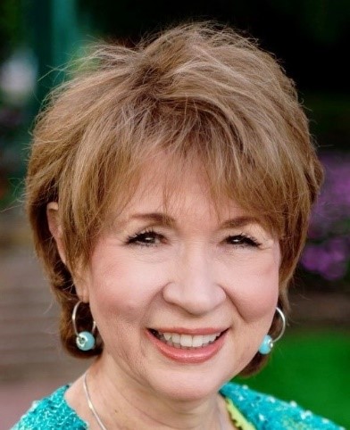 A woman with short hair and wearing earrings.